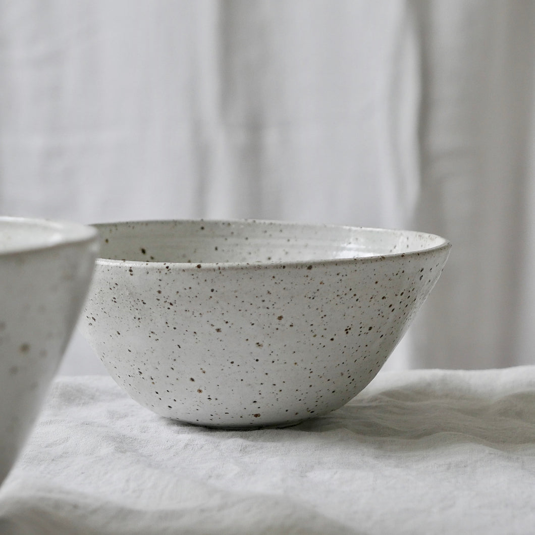 white flecked shiny curved bowl