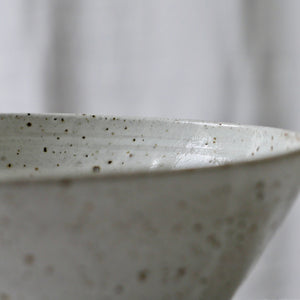 white flecked shiny curved bowl