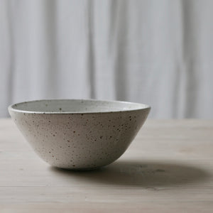 white flecked shiny curved bowl